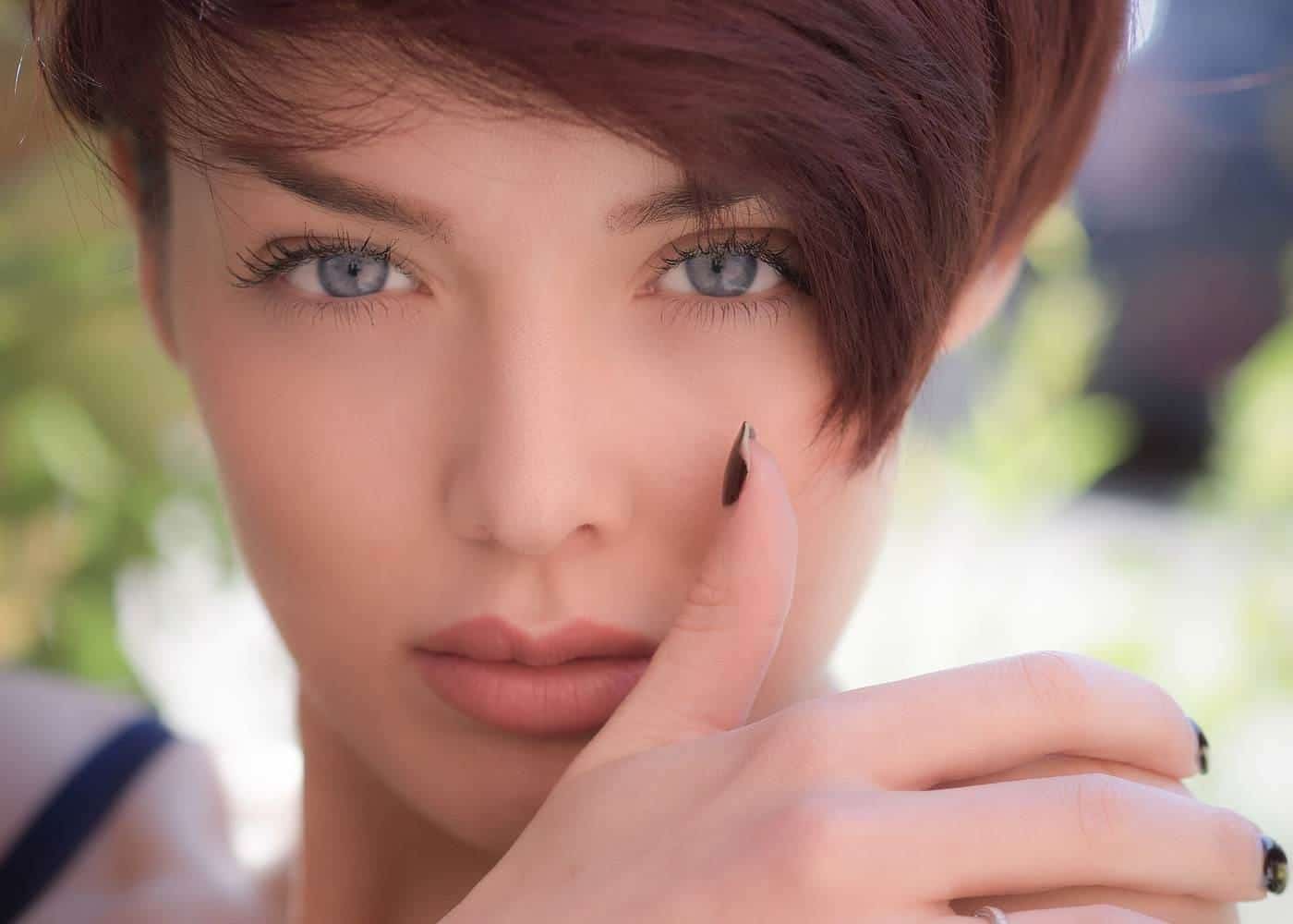 A natural light portrait of a woman with her hand near her face