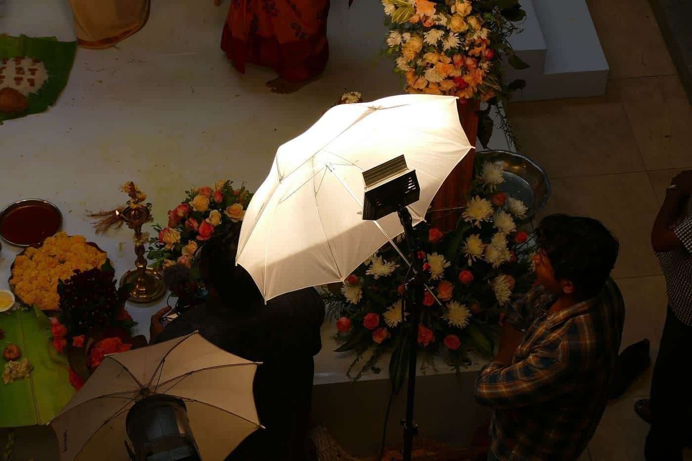 A photographer holding a large reflector during a shoot
